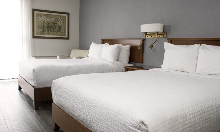 Vue d'une chambre Côté Jardins à 2 lits Queen avec tapis